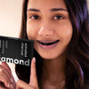 Woman with activated charcoal tooth whitening strips for teeth whitening at home