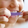 Woman Using Diamond Smile tooth whitening strips to whiten teeth at home