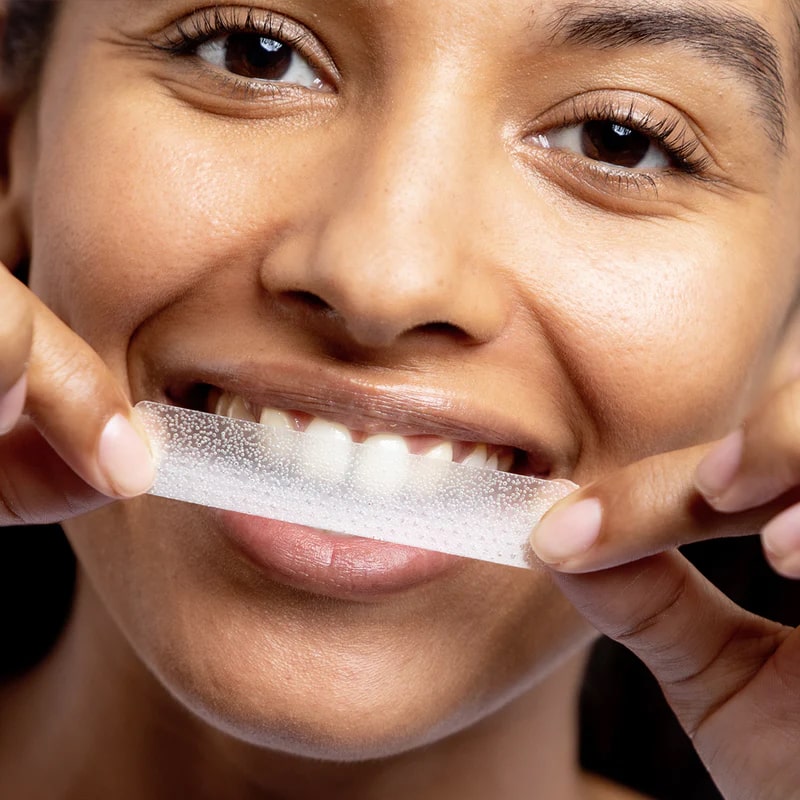 Woman with PAP+ tooth whitening strips from Diamond Smile