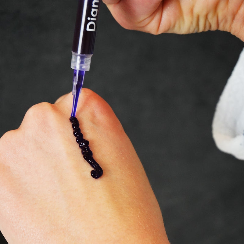 Diamond Smile purple tooth-whitening gel on hand.