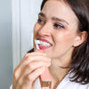 Woman brushing her teeth with Diamond Smile PAP+ Teeth Whitening Powder