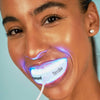 Woman using Diamond Smile Power+ phone-bleaching mouthpiece with LED tray