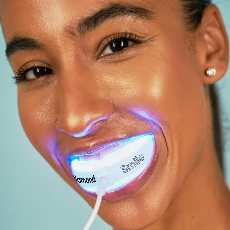 Woman using Diamond Smile Power+ phone-bleaching mouthpiece with LED tray
