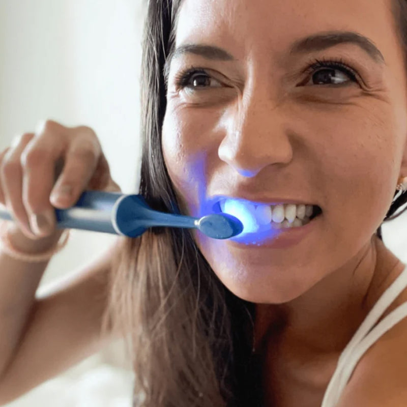 Woman with Power LED Bleaching sonic toothbrush from Diamond Smile in her hand