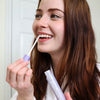Woman in the bathroom holding the Diamond Smile Bleaching Glow Stick
