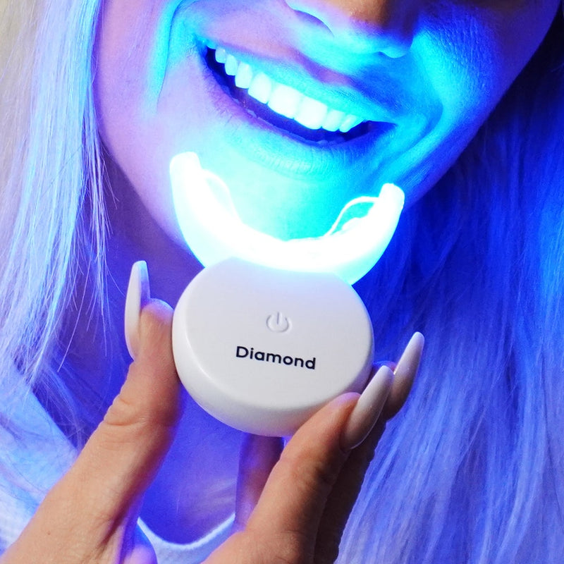Purple tooth-whitening set mouthpiece with LED lamp in hand – Diamond Smile